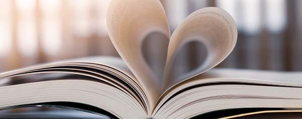 Ein offenes Buch, aus dem ein Herz herausgeschnitten ist.