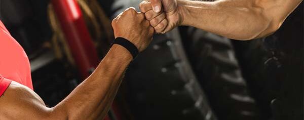 Zwei Männer schütteln sich in einem Fitnessstudio die Hand.