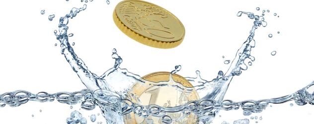 Eine Münze fällt in einen Wasserspritzer.