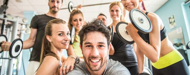 Eine Gruppe von Menschen posiert in einem Fitnessstudio für ein Foto.