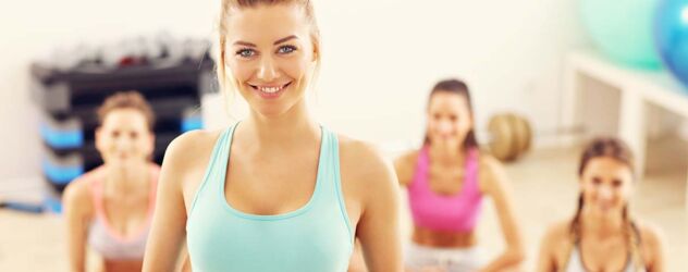Eine Gruppe von Frauen macht Yoga in einem Fitnessstudio.