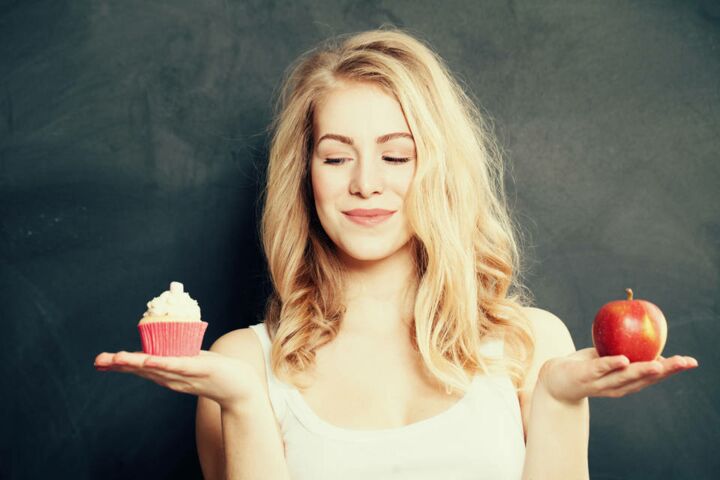 Ernährungsberaterin wählt zwischen Cupcake und gesundem Obst