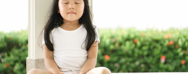 Süßes Mädchen sitzt auf der Terassenboden und meditiert