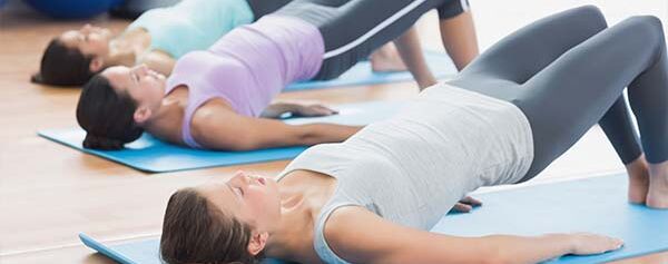 Eine Gruppe von Frauen macht Yoga in einem Fitnessstudio.