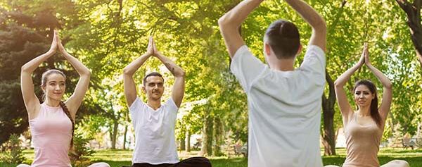 Eine Gruppe von Menschen macht Yoga im Park.