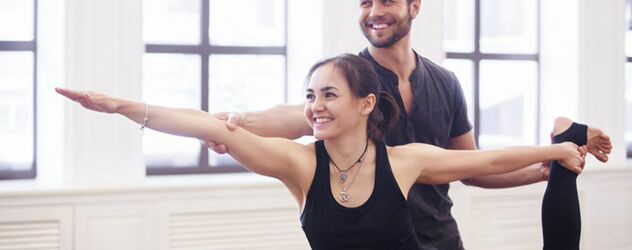 Ein Mann und eine Frau praktizieren Yoga in einem Studio.