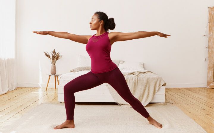 Frau in der stolzen aufrechten Yoga Übung Krieger 2